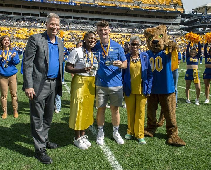 Chancellor Gallagher, De'Jovia Davis, Ian Montelius, Valerie Njie and Roc in football field during Homecoming