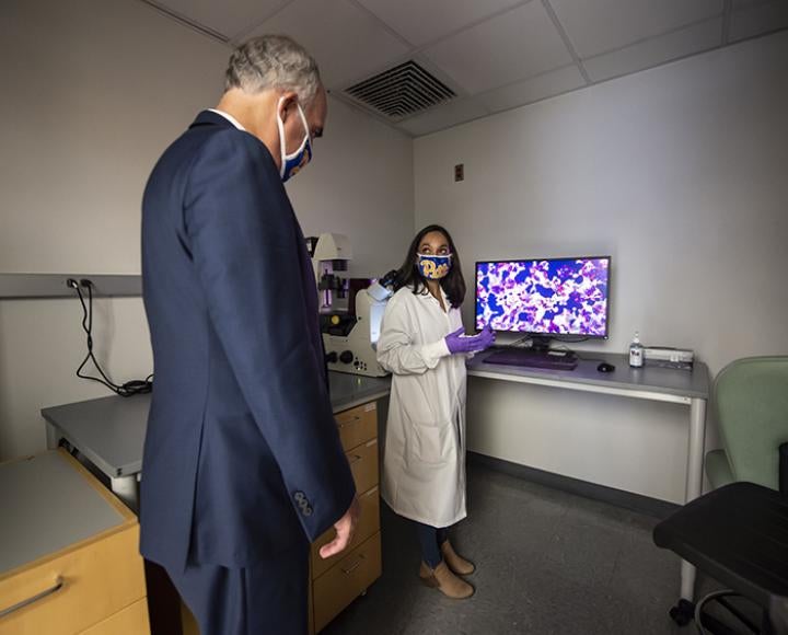 Natasha Tilston-Lunel shows Bob Casey a cell infected with SARS-CoV-2