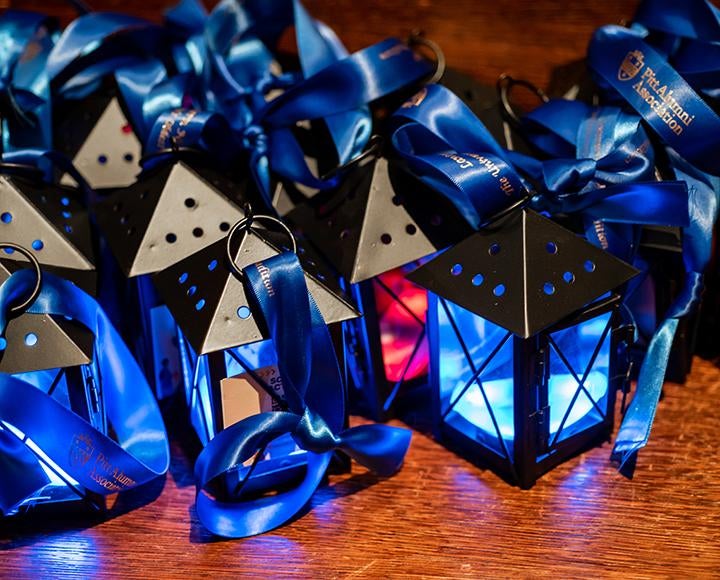 black lanterns with blue ribbons, aglow