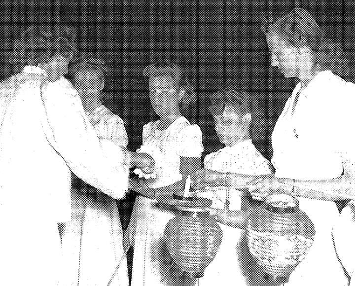 a black and white photo of women lighting paper lanterns