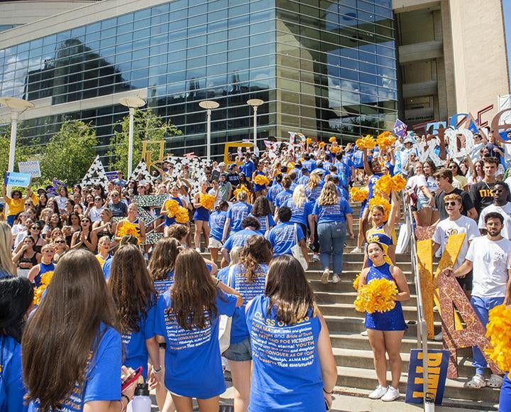 hundreds of students in blue and gold climbing the Pete stairs