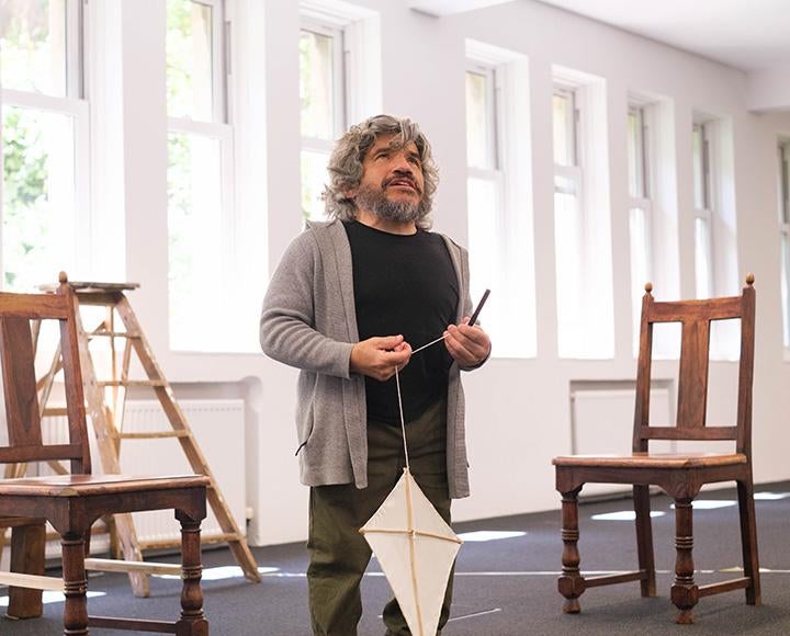 An actor with dwarfism delivers lines while holding paper kite