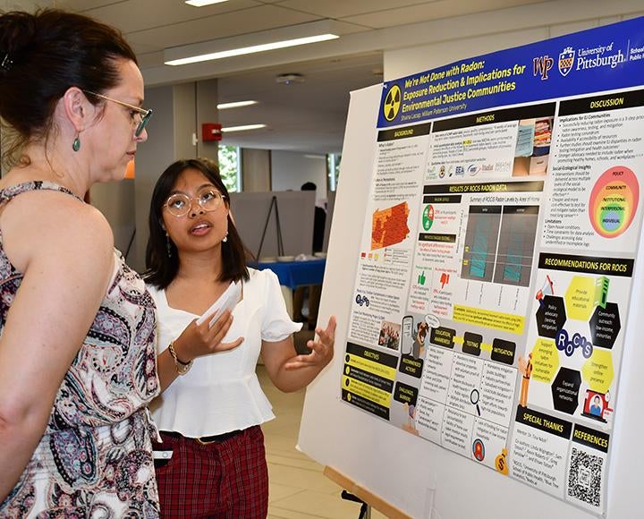 Lacap explains her research to a symposium attendee