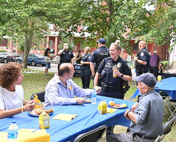 A police officer talks with people at a picnic table