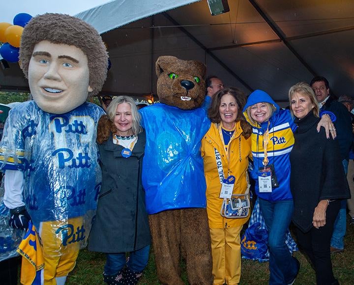 A group of alumni with a panther mascot at a tailgate