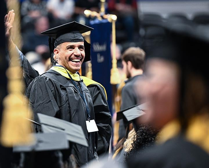 A graduate smiles in a crowd