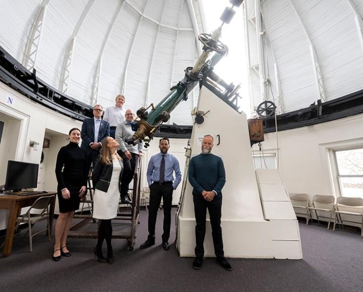 Faculty gather around a telescope inside the Allegheny Observatory dome