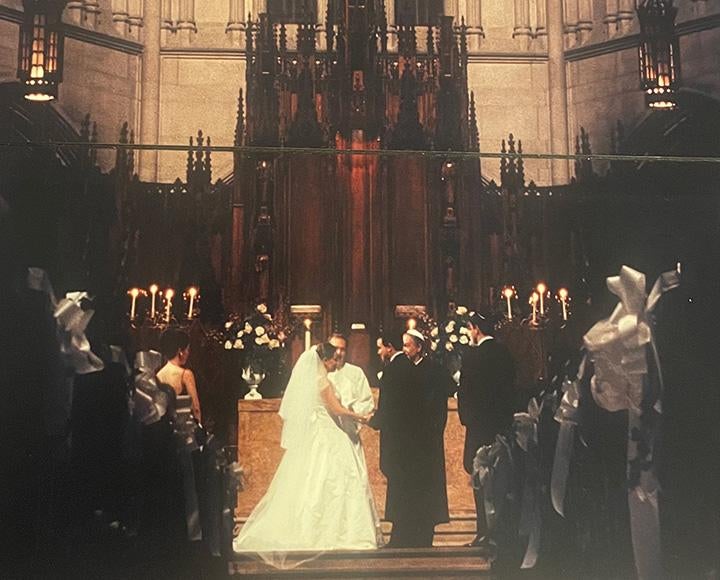 An aged photo of a wedding in front of the chapel's organ