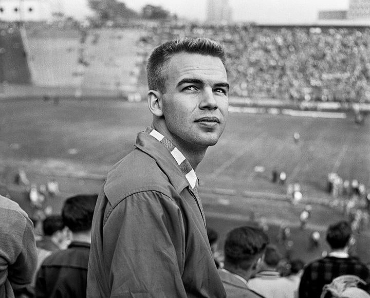 A black and white photo of a student in the Pitt Stadium stands