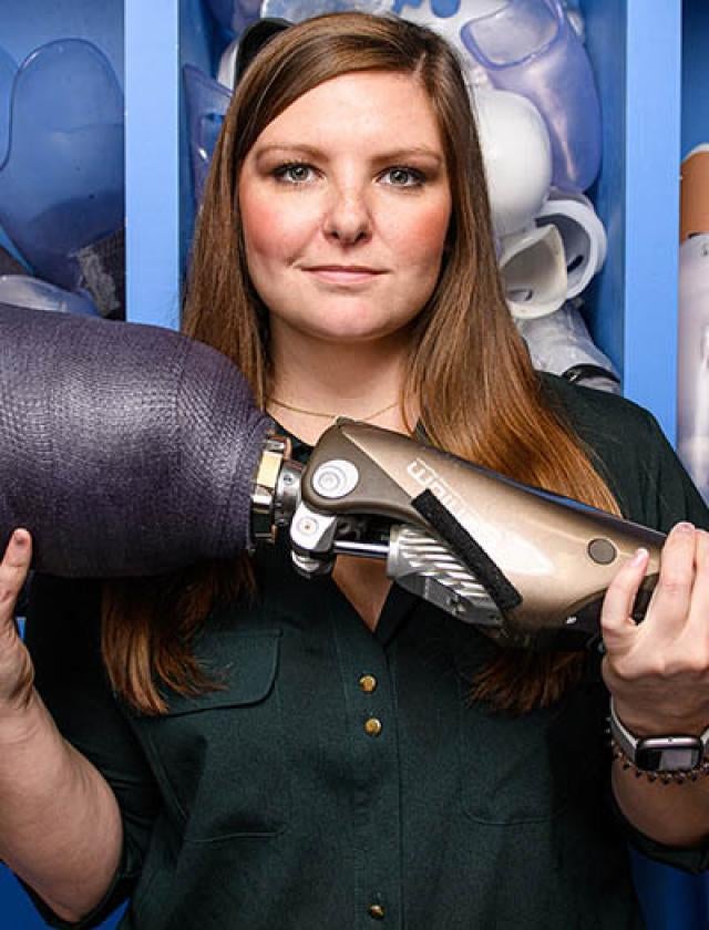 Annie Kaitlyn Caulfield holding a prosthetic limb