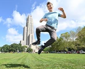 Lafferty jumps on the lawn in front of the Cathedral of Learning