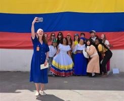 Foladare takes a selfie with a group against an Ecuador flag