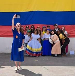Foladare takes a selfie with a group against an Ecuador flag