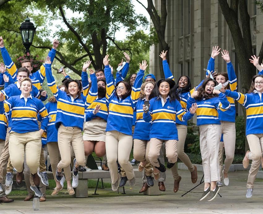 Students in blue and gold jumping together