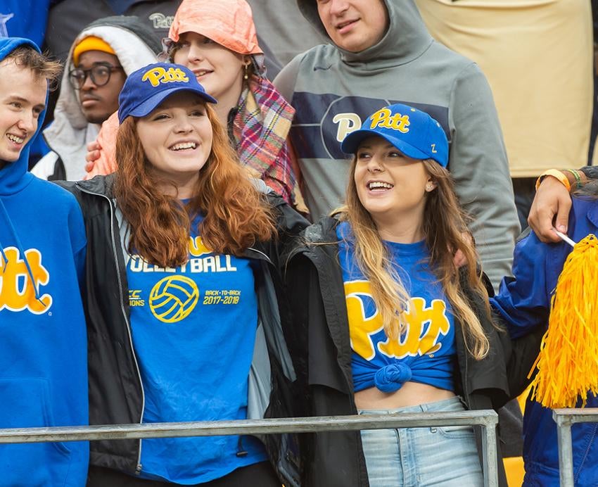 Four students wearing Pitt attire during Homecoming