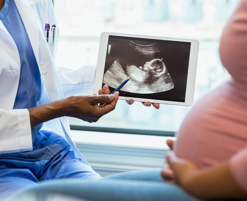 Health professional showing ultrasound to pregnant woman 