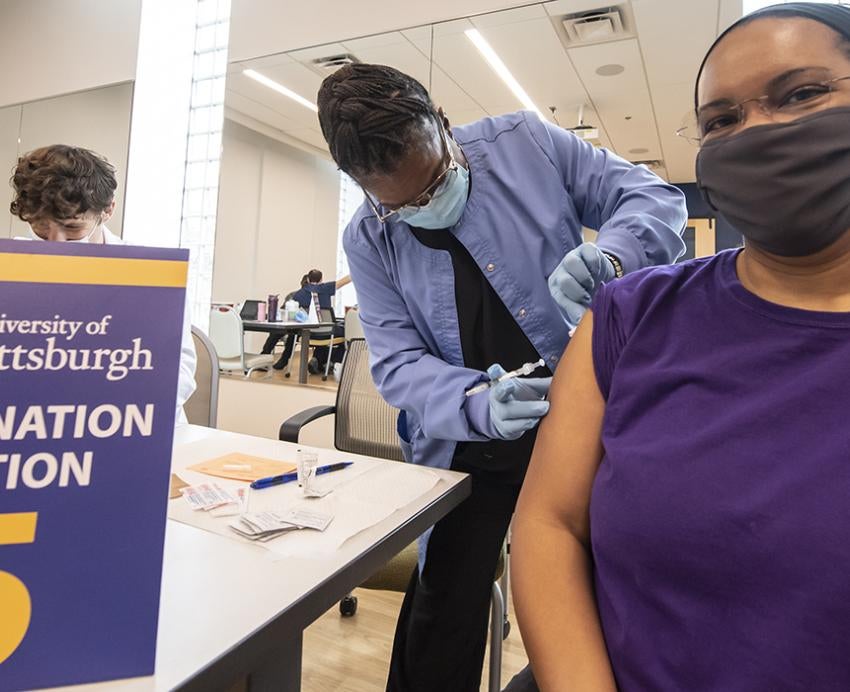 Woman in purple shirt getting a vaccine at a clinic in Homewood