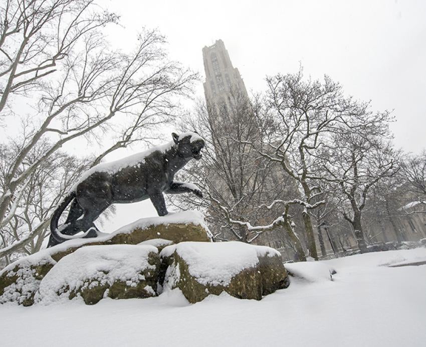 Panther statue covered with snow in front of Cathedral of Learning