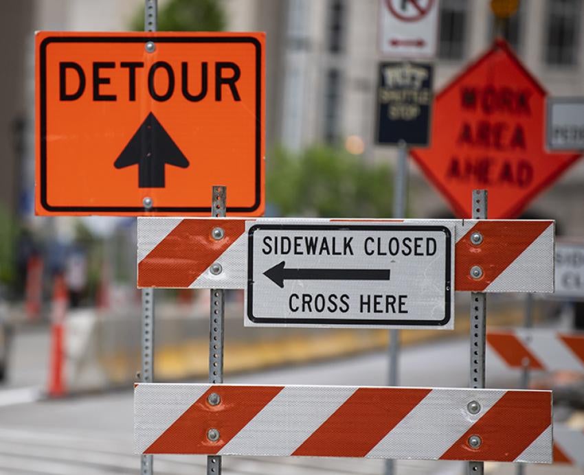Bright orange detour and road closure signs in the street