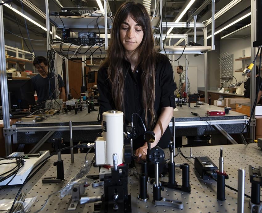 a woman working at a table filled with thermophysics equipment