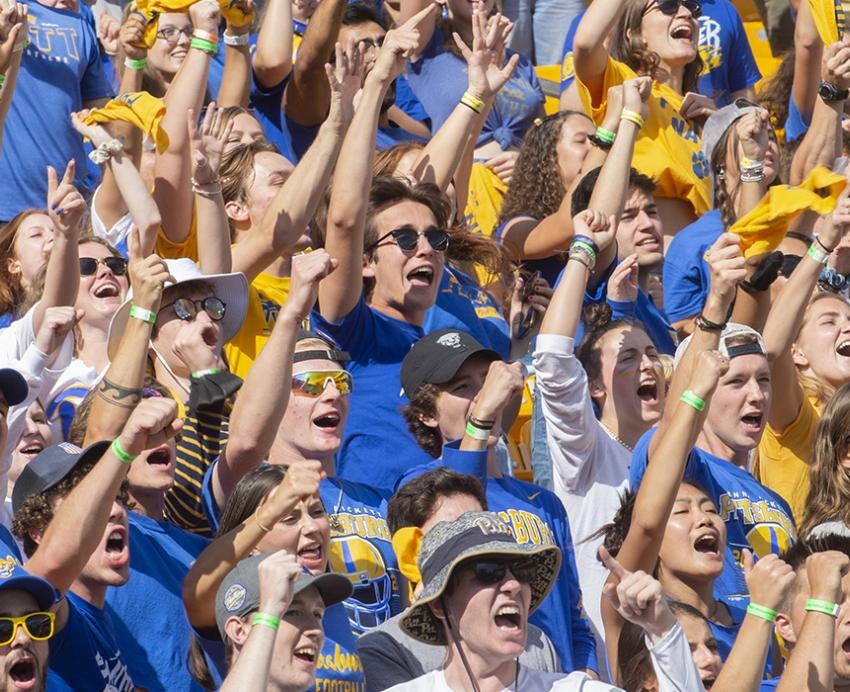 Pitt fans wearing blue and yellow cheering during homecoming