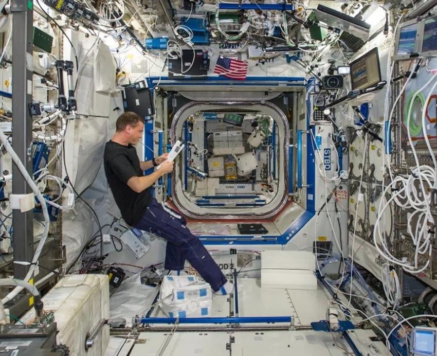 Man reading paper inside space station