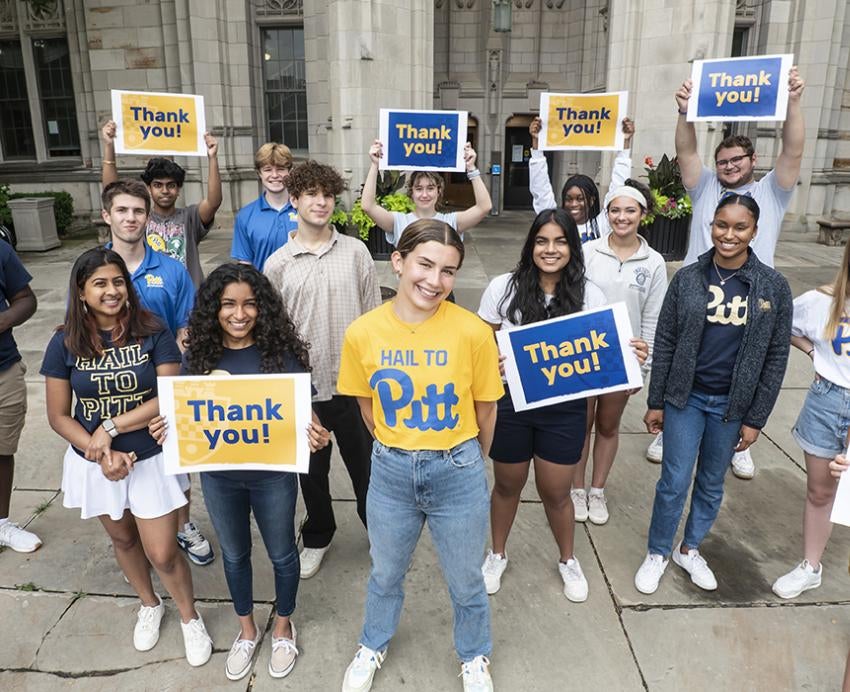 a group of students outside the Cathedral holding "thank you" signs