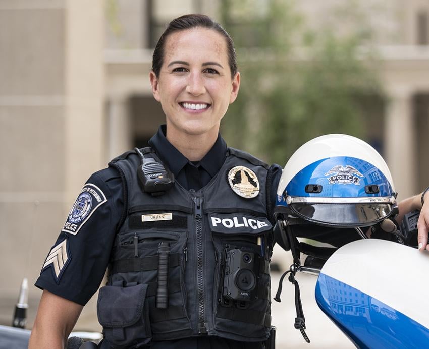 Urban in uniform leaning on her bike
