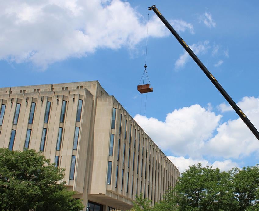 a crane hoisting something over Hillman Library