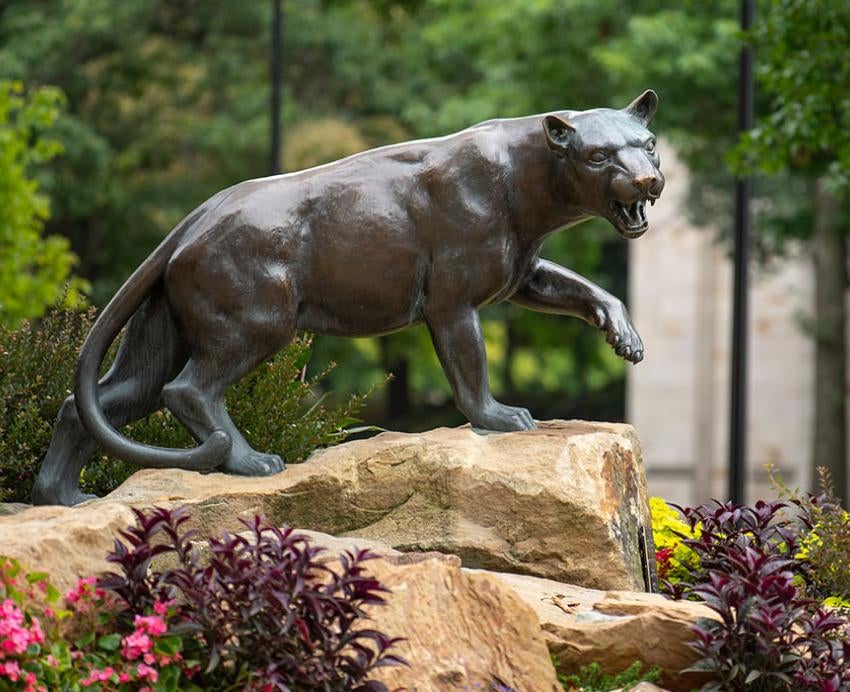 a Panther statue surrounded by lush flowers