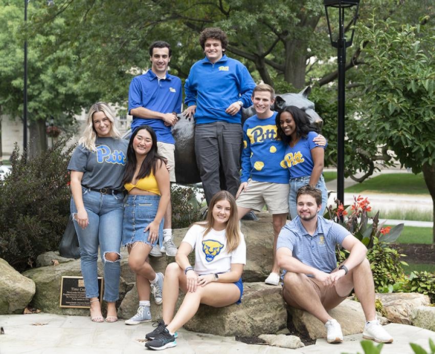 8 students in Pitt gear around a Panther statue