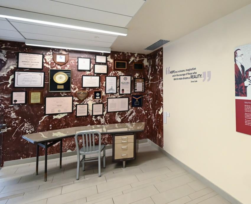 plaques and documents hung on the wall above Salk's desk