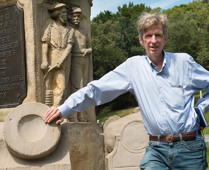 Kirk Savage leans on a monument
