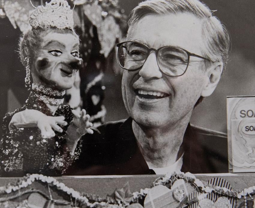 Fred Rogers controls a puppet in a black-and-white archival photo