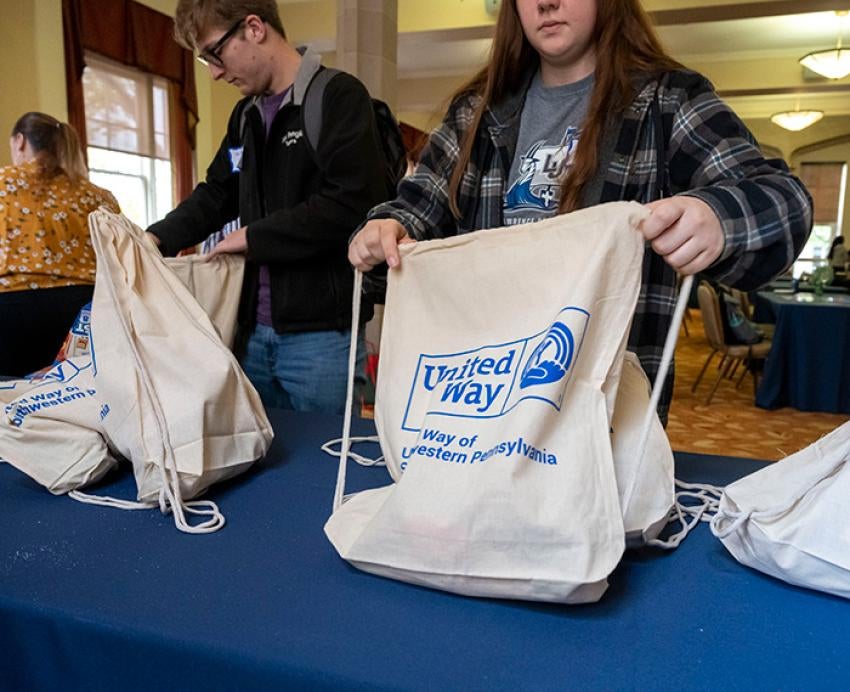 People pack drawstring bags that have a United Way logo