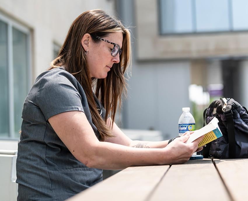 A person reads at an outdoor table