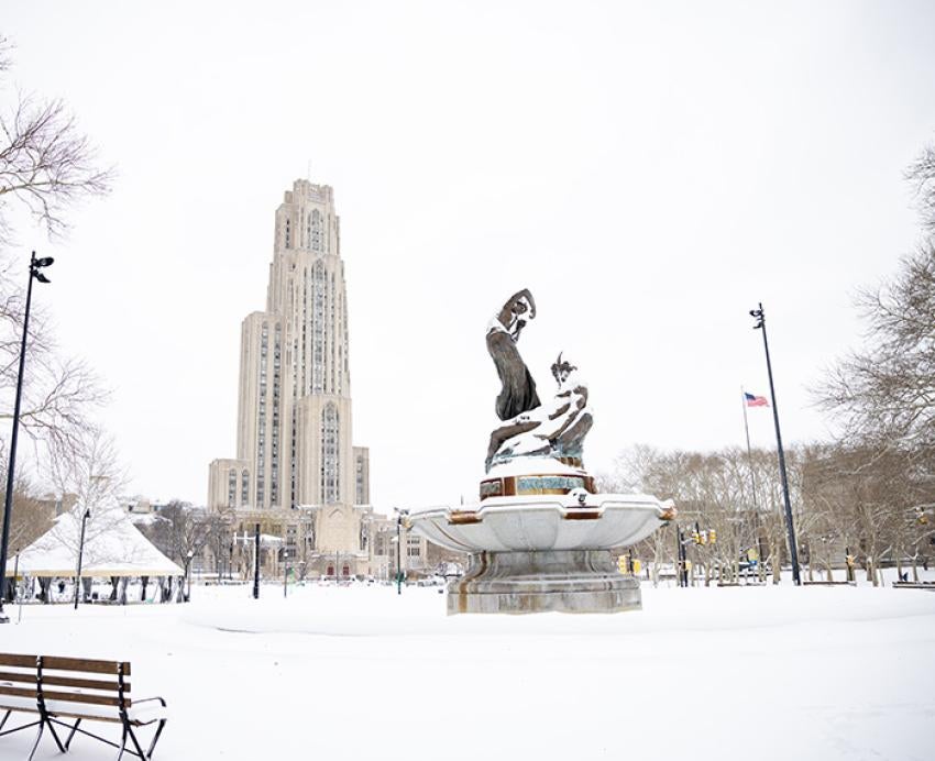 A snow-covered fountain in front of the Cathedral of Learning