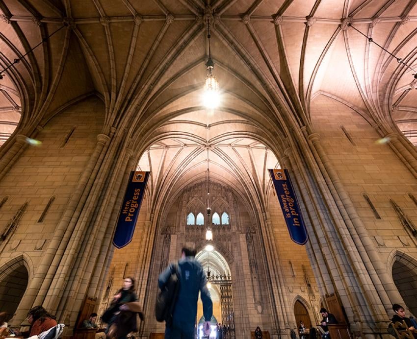 A person walks through the doorway to the Commons Room in the Cathedral of Learning
