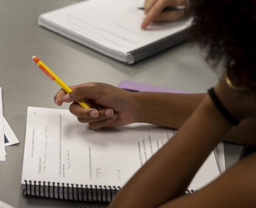 Student holding a pencil and looking at a notebook