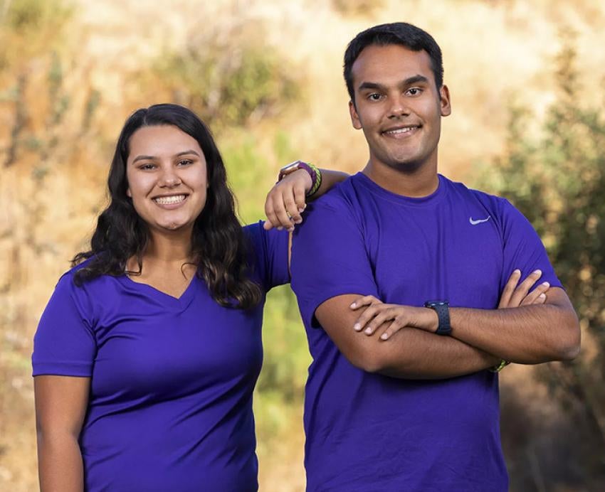 Maya and her brother pose in matching purple shirts