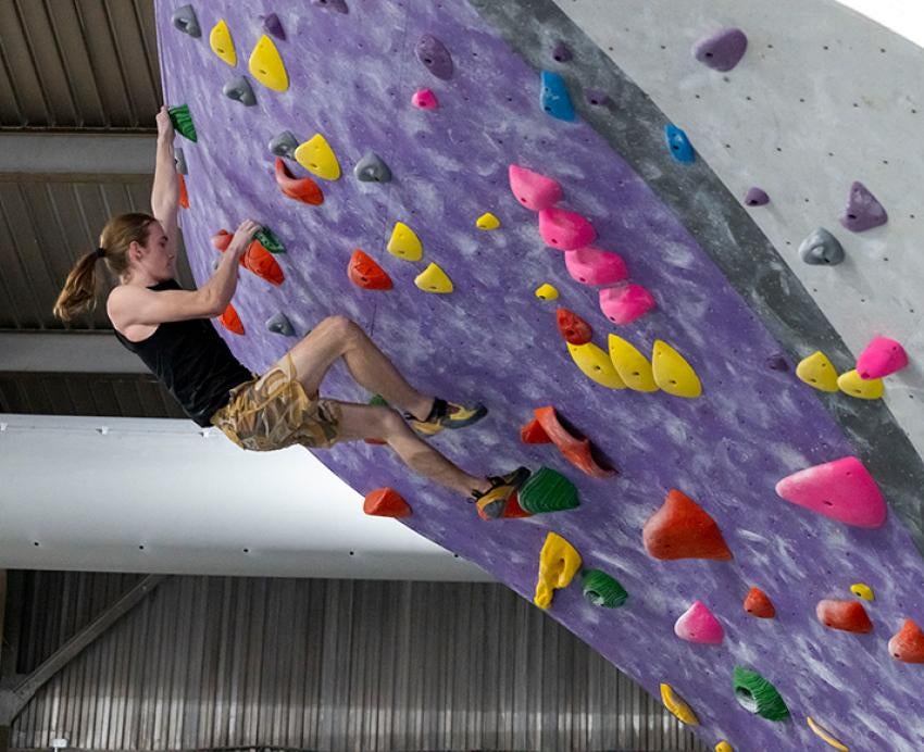 A climber scales an indoor rock wall