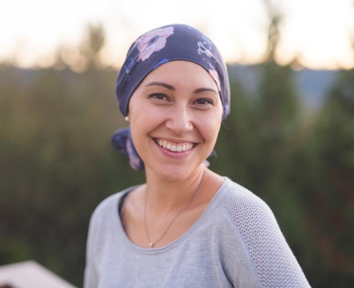 a woman in a gray shirt wearing a head scarf