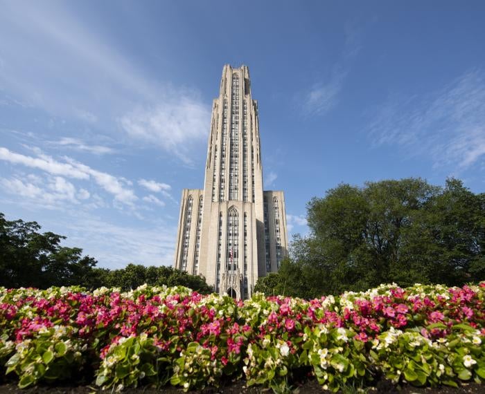 Cathedral of Learning with red flowers in the foreground