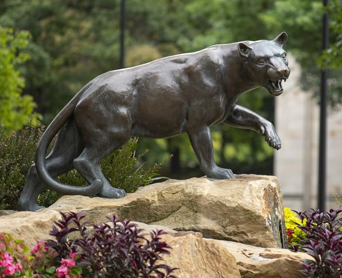 Panther statue next to colorful flowers