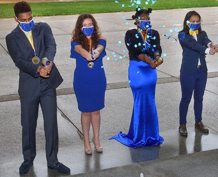 Homecoming court students dressed up using confetti poppers
