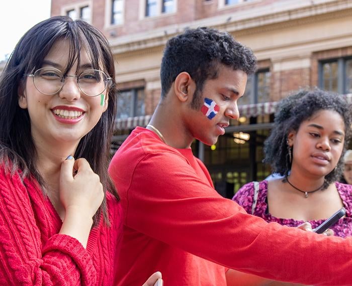 Students wearing red with face paint, celebrating Hispanic Heritage Month