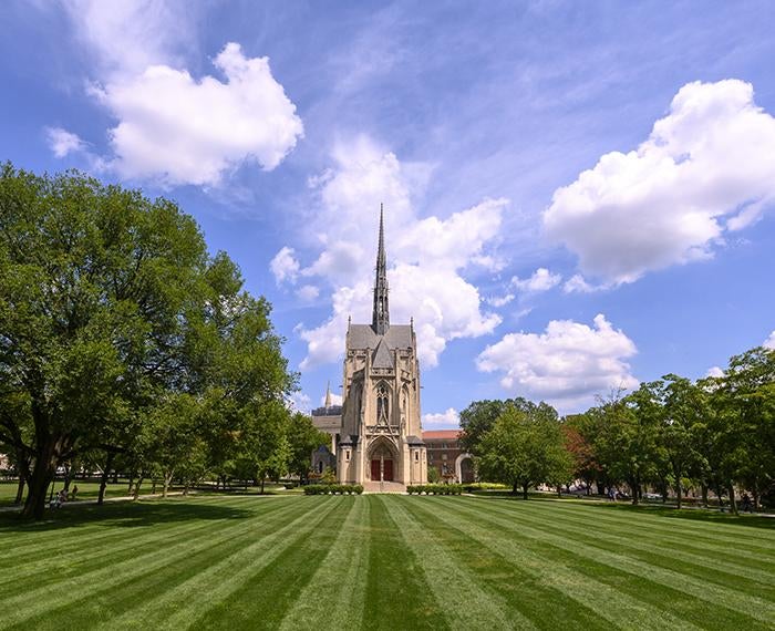 Heinz Chapel behind large field of grass during sunny day