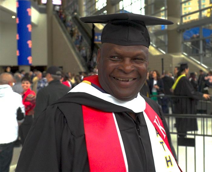 Jackson in a black cap and gown with red and white stoles