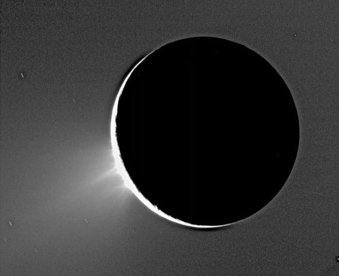 Light shines around the edge of Saturn's moon Enceladus