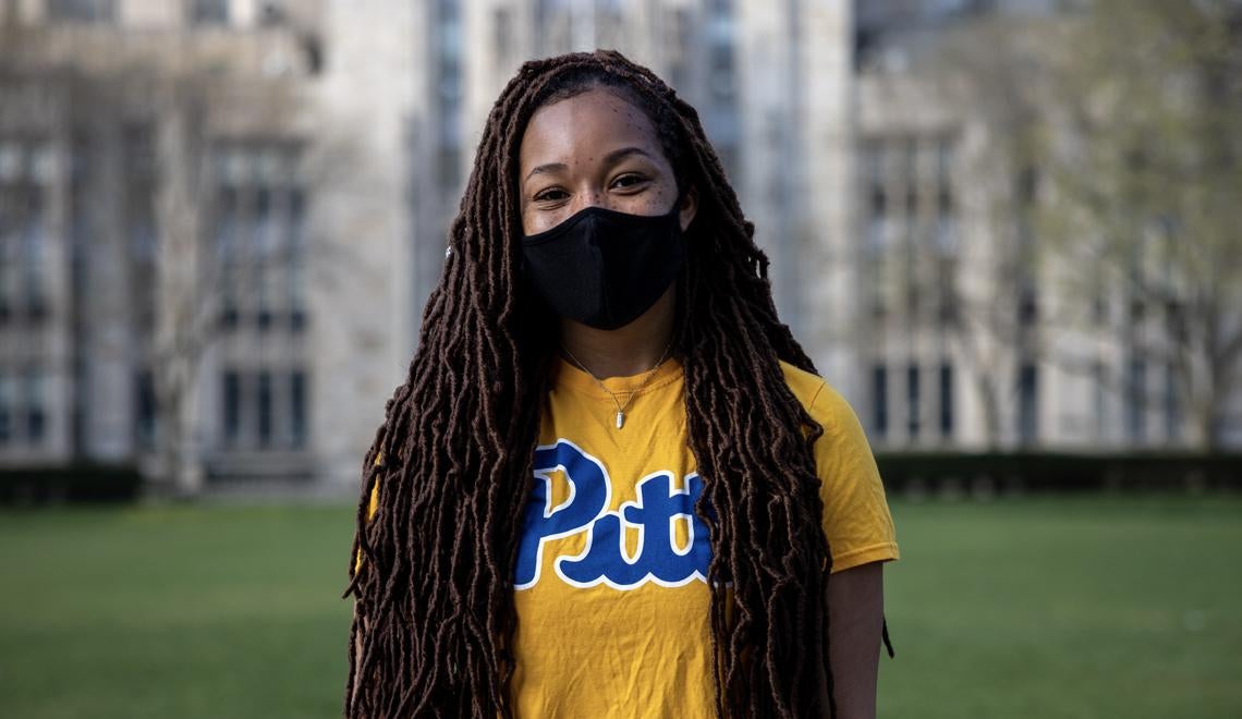 Pitt student in mask and gold pitt shirt